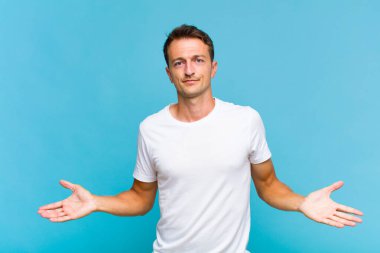 Genç yakışıklı adam şaşkın ve şaşkın hissediyor, doğru cevap veya karardan emin değil, bir seçim yapmaya çalışıyor.
