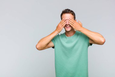 Genç yakışıklı adam gülümsüyor ve mutlu hissediyor, iki eliyle gözlerini kapatıyor ve inanılmaz bir sürpriz bekliyor.