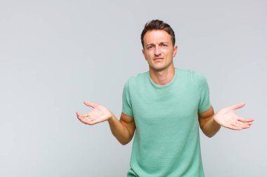 Şaşkın, şaşkın ve stresli görünen genç bir adam. Farklı seçenekler arasında merak ediyor. Belirsiz hissediyor.