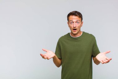 Genç, yakışıklı, ağzı açık ve şaşkın, şok olmuş ve şaşırmış bir adam.