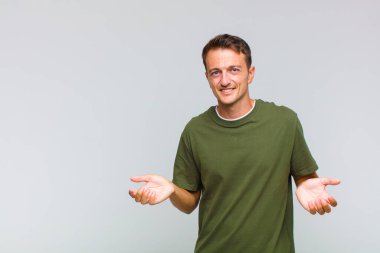 Genç yakışıklı bir adam bilgisiz ve kafası karışık, hangi seçeneği seçeceğinden emin değil, merak ediyor.