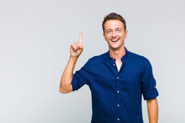 Genç yakışıklı bir adam bir fikri fark ettikten sonra mutlu ve heyecanlı bir dahi gibi hissediyor, neşeli bir şekilde parmağını kaldırıyor, eureka!