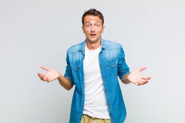 Genç, yakışıklı, ağzı açık ve şaşkın, şok olmuş ve şaşırmış bir adam.