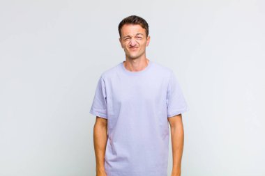 Genç ve yakışıklı adam şapşal ve komik görünüyor. Şaşı bakışlı, şakacı ve şakacı.