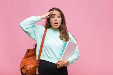 Genç İspanyol kadın mutlu, şaşkın ve şaşırmış görünüyor, gülümsüyor ve inanılmaz ve inanılmaz iyi haberleri fark ediyor.