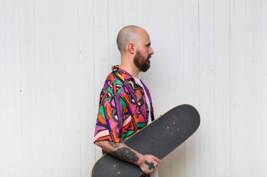 Kel adam profil görünümünde. İlerideki boşluğu kopyalamak istiyor. Düşünüyor, hayal ediyor ya da hayal ediyor.