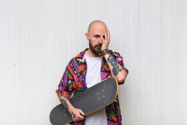 Kel bir adam yorgun, sıkıcı ve can sıkıcı bir işten sonra sıkılmış, hayal kırıklığına uğramış ve uykulu hisseder.