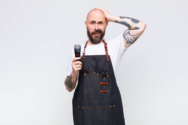 Kel adam kendini stresli, endişeli, endişeli ya da korkmuş hissediyor, elleri başının üstünde, hata yaptığında panikliyor.