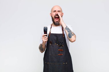 Kel adam mutlu, heyecanlı ve pozitif hissediyor. Elleri ağızda, bağırarak bağırıyor.