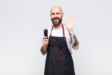 Kel adam gülümsüyor ve arkadaş canlısı görünüyor, iki ya da iki numarayı gösteriyor, eli önde, geriye doğru sayıyor.