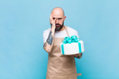 Kel bir adam yorgun, sıkıcı ve can sıkıcı bir işten sonra sıkılmış, hayal kırıklığına uğramış ve uykulu hisseder.