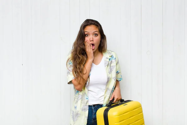 stock image young hispanic woman feeling shocked and scared, looking terrified with open mouth and hands on cheeks