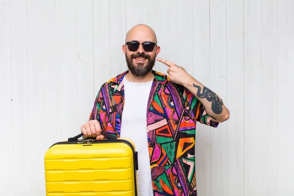 bald man smiling confidently pointing to own broad smile, positive, relaxed, satisfied attitude