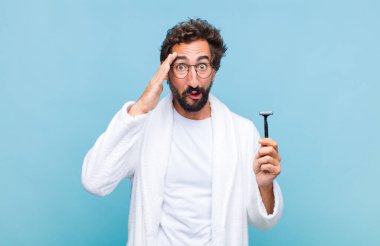 Genç sakallı adam mutlu, şaşkın ve şaşırmış görünüyor, gülümsüyor ve inanılmaz ve inanılmaz iyi haberleri fark ediyor.