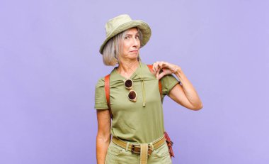 Orta yaşlı bir kadın kibirli, başarılı, pozitif ve gururlu görünüyor.