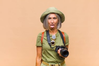 Orta yaşlı bir kadın tiksinmiş ve rahatsız olmuş hissediyor. Dilini dışarı çıkarıyor. İğrenç ve iğrenç bir şeyden hoşlanmıyor.