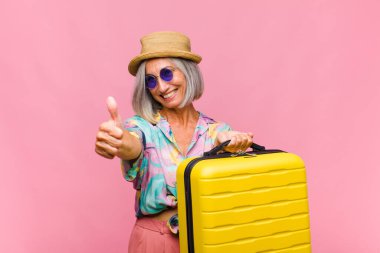 Orta yaşlı bir kadın gururlu, tasasız, kendinden emin ve mutlu, olumlu gülümsüyor.