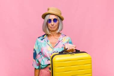 Orta yaşlı bir kadın üzgün, üzgün ya da kızgın ve olumsuz bir tavır takınıyor, anlaşmazlık içinde kaşlarını çatıyor.