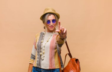 Orta yaşlı bir kadın gururla gülümsüyor ve gururla bir numaralı pozunu veriyor, kendini lider gibi hissediyor.