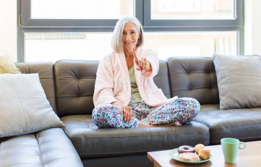 Orta yaşlı bir kadın gülümsüyor ve arkadaş canlısı görünüyor. Bir numara ya da ilk eli önde, geriye doğru sayıyor.