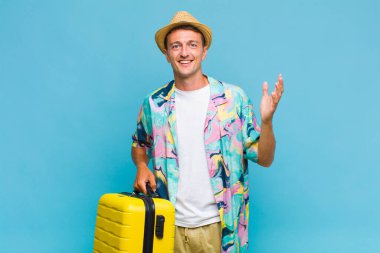 Genç yakışıklı adam kendini mutlu, şaşırmış ve neşeli hissediyor. Pozitif bir tavırla gülümsüyor. Bir çözüm ya da fikir buluyor.