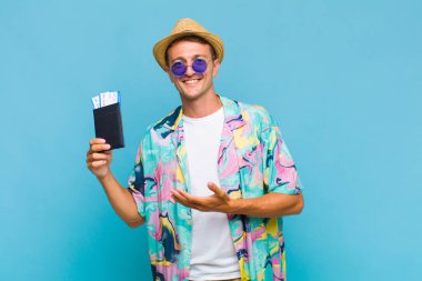 Genç yakışıklı adam neşeyle gülümsüyor, mutlu hissediyor ve fotokopi uzayında bir konsept gösteriyor.