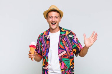 Genç yakışıklı adam mutlu, heyecanlı, şaşırmış ya da şok olmuş hissediyor, gülümsüyor ve hayrete düşüyor.