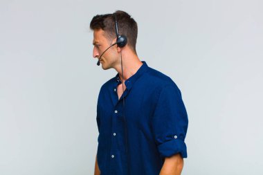 Profil görünümündeki genç yakışıklı adam ilerideki boşluğu kopyalamaya çalışıyor, düşünüyor, hayal ediyor ya da hayal kuruyor.