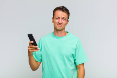 Genç yakışıklı adam üzgün ve mızmız, mutsuz bir bakışla, olumsuz ve hayal kırıklığına uğramış bir tavırla ağlıyor.