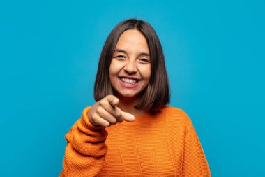 İspanyol kadın kameraya tatmin olmuş, kendinden emin, dost canlısı bir gülümsemeyle bakıyor ve seni seçiyor.