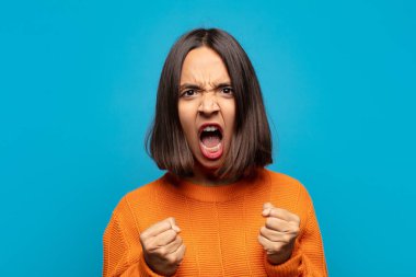 İspanyol kadın sinirli, sinirli, sinirli bakışlar ve sıkı yumruklar ile agresif bir şekilde bağırıyor.