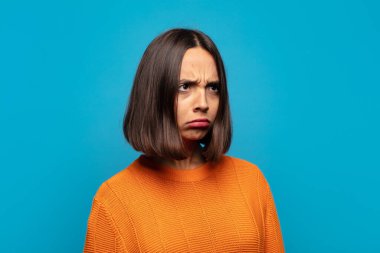 Hispanik kadın üzgün, üzgün ya da kızgın ve olumsuz bir tavır takınıyor, anlaşmazlık içinde kaşlarını çatıyor.