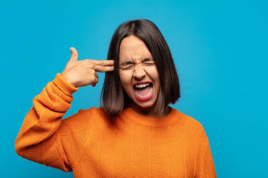 İspanyol kadın mutsuz ve stresli görünüyor, intihar jesti elle silah işareti yapıyor, kafasını işaret ediyor.