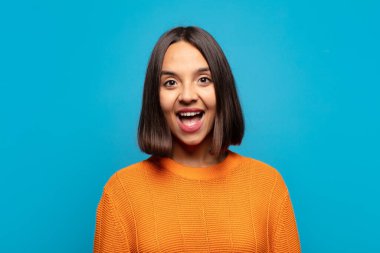 İspanyol kadın mutlu ve hoş bir şekilde şaşırmış görünüyor. Büyülenmiş ve şok olmuş bir ifadeyle heyecanlanıyor.