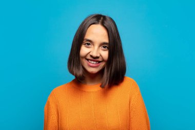 İspanyol kadın neşeli, mutlu, kendinden emin ve rahat bir ifadeyle gülümsüyor.