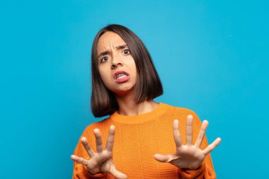 İspanyol kadın korkmuş, geri çekiliyor ve korku ve panik içinde bağırıyor, kabusa tepki veriyor.