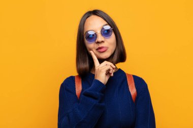 İspanyol kadın mutlu bir şekilde gülümsüyor ve hayal kuruyor ya da şüphe ediyor.