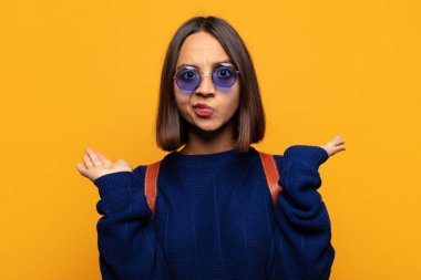 İspanyol kadın şaşkın ve kafası karışık, şüpheci, farklı seçenekleri tartıyor ya da komik bir ifadeyle seçiyor.