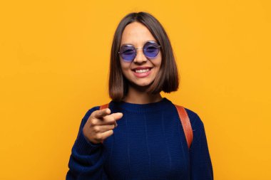 İspanyol kadın kameraya tatmin olmuş, kendinden emin, dost canlısı bir gülümsemeyle bakıyor ve seni seçiyor.