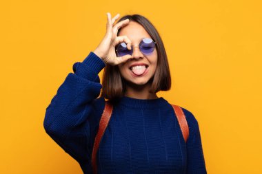 İspanyol kadın mutlu bir şekilde gülümsüyor, şaka yapıyor, gözetleme deliğinden bakıyor, sırları gözetliyor.