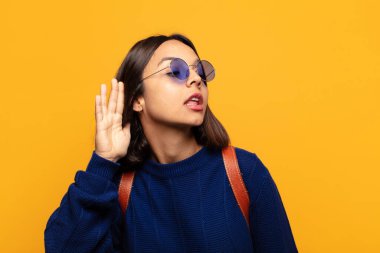 İspanyol kadın gülümsüyor, tuhaf bir şekilde yan tarafa bakıyor, dedikoduları dinlemeye ya da bir sırrı duymaya çalışıyor.