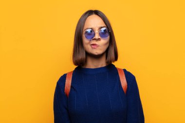 İspanyol kadın şaşkın ve şaşkın görünüyor, merak ediyor ya da bir sorunu çözmeye çalışıyor ya da düşünüyor.