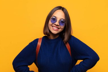 İspanyol kadın neşeli, mutlu, kendinden emin ve rahat bir ifadeyle gülümsüyor.