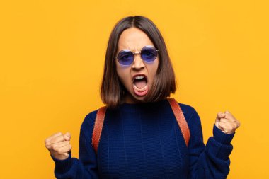 Öfkeli bir ifadeyle saldırganca bağıran İspanyol kadın mı yoksa başarıyı kutlayan yumruklarla mı?