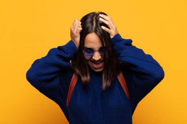 İspanyol kadın kendini stresli ve hayal kırıklığına uğramış hissediyor, elele tutuşuyor, yorgun, mutsuz ve migren ağrısı çekiyor.