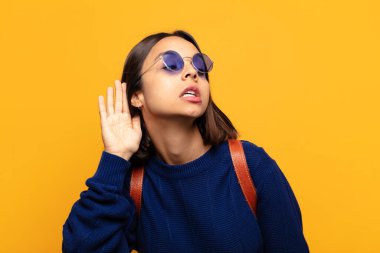 İspanyol kadın ciddi ve meraklı görünüyor, dinliyor, gizli bir konuşma ya da dedikodu duymaya çalışıyor, gizlice dinliyor.