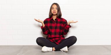 İspanyol kadın şaşkın ve kafası karışık, şüpheci, farklı seçenekleri tartıyor ya da komik bir ifadeyle seçiyor.