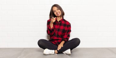 İspanyol kadın kameraya tatmin olmuş, kendinden emin, dost canlısı bir gülümsemeyle bakıyor ve seni seçiyor.