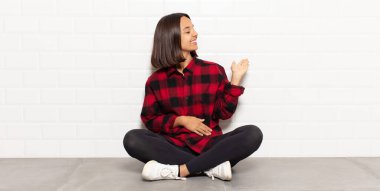 İspanyol kadın kendini mutlu ve neşeli hissediyor, gülümsüyor ve seni hoş karşılıyor, seni dostça bir jestle içeri davet ediyor.