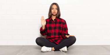 İspanyol kadın ciddi, sert, hoşnutsuz ve kızgın görünüyor. Avuç içinin açık olması jesti durduruyor.